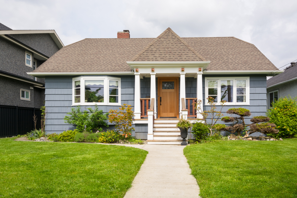 A small blue house in a suburban neighborhood.