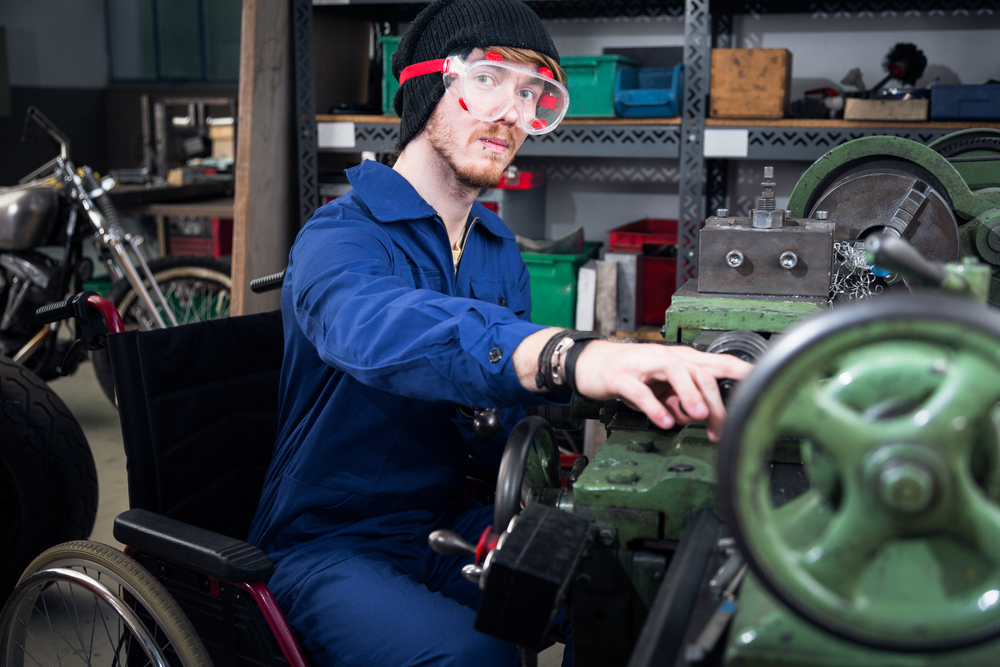 Young Mechanic who uses Wheelchair Working On Turning Lathe