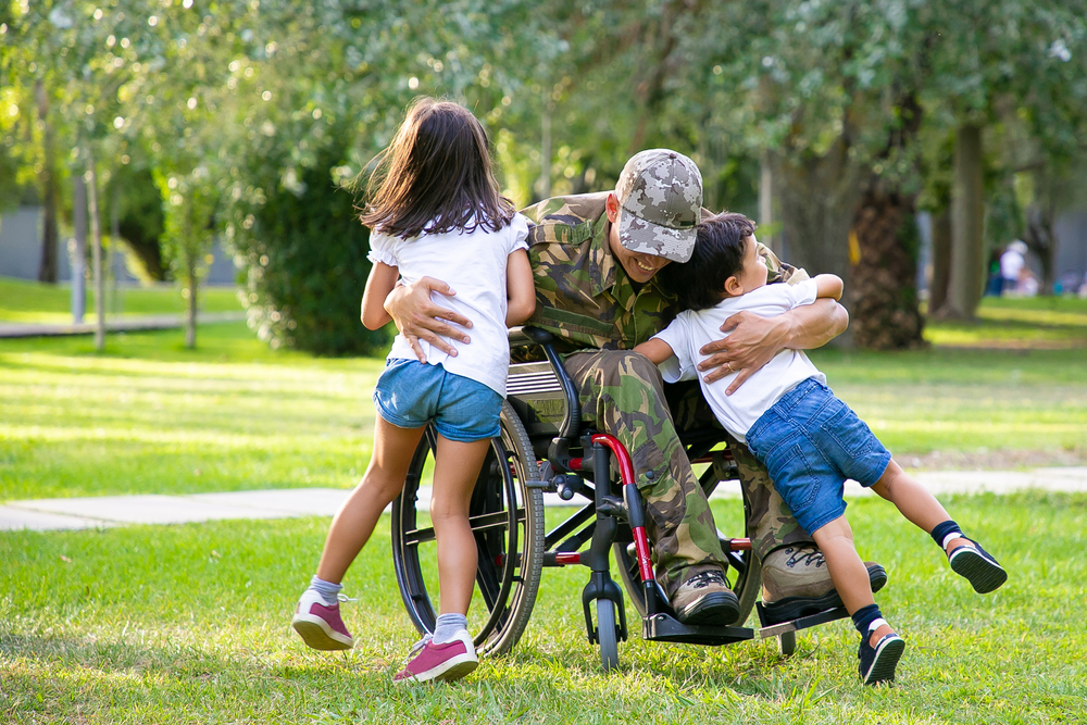 Military veteran who uses wheelchair hugging kids outside